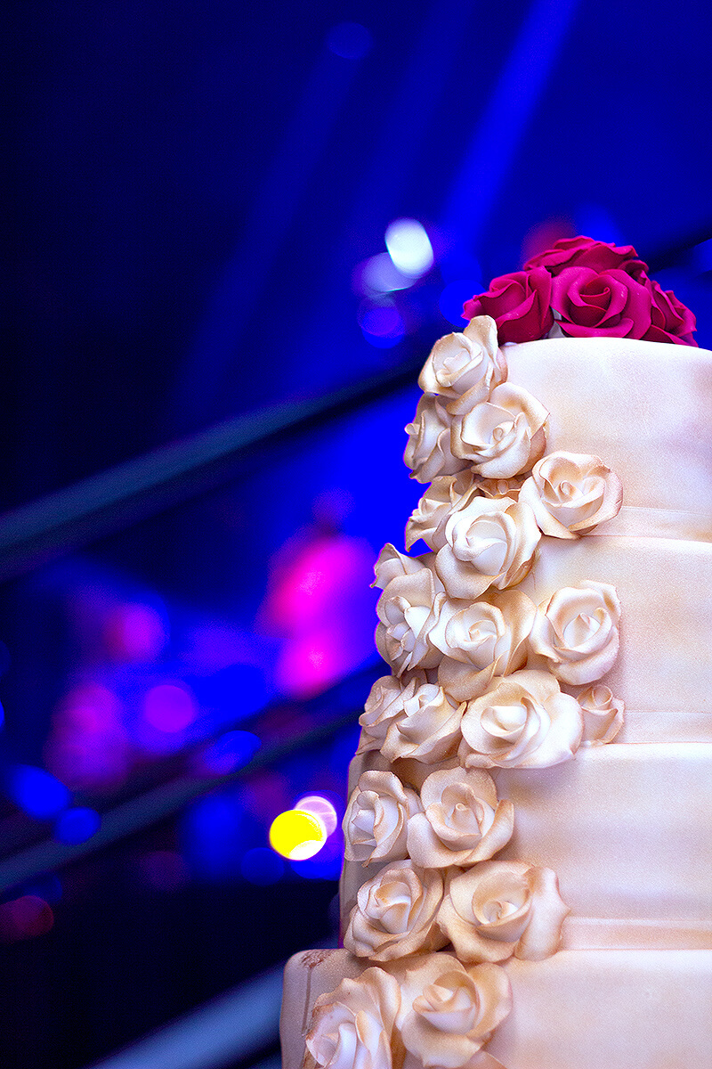 Close up shot of white wedding cake with rose decoration