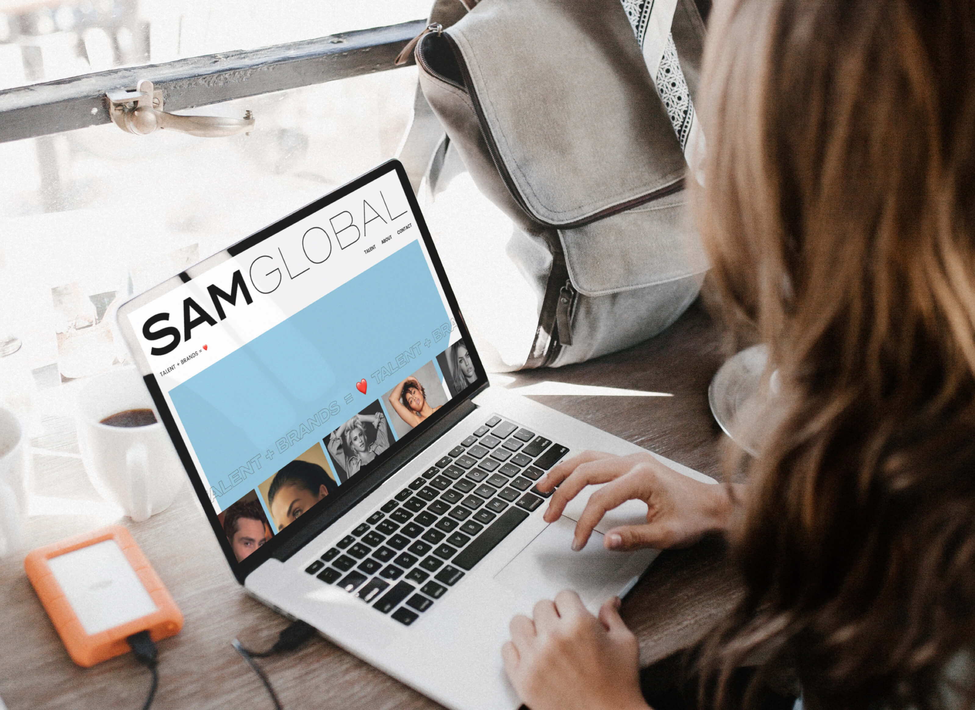 Aerial view of lady working on macbook showing SAM Global website