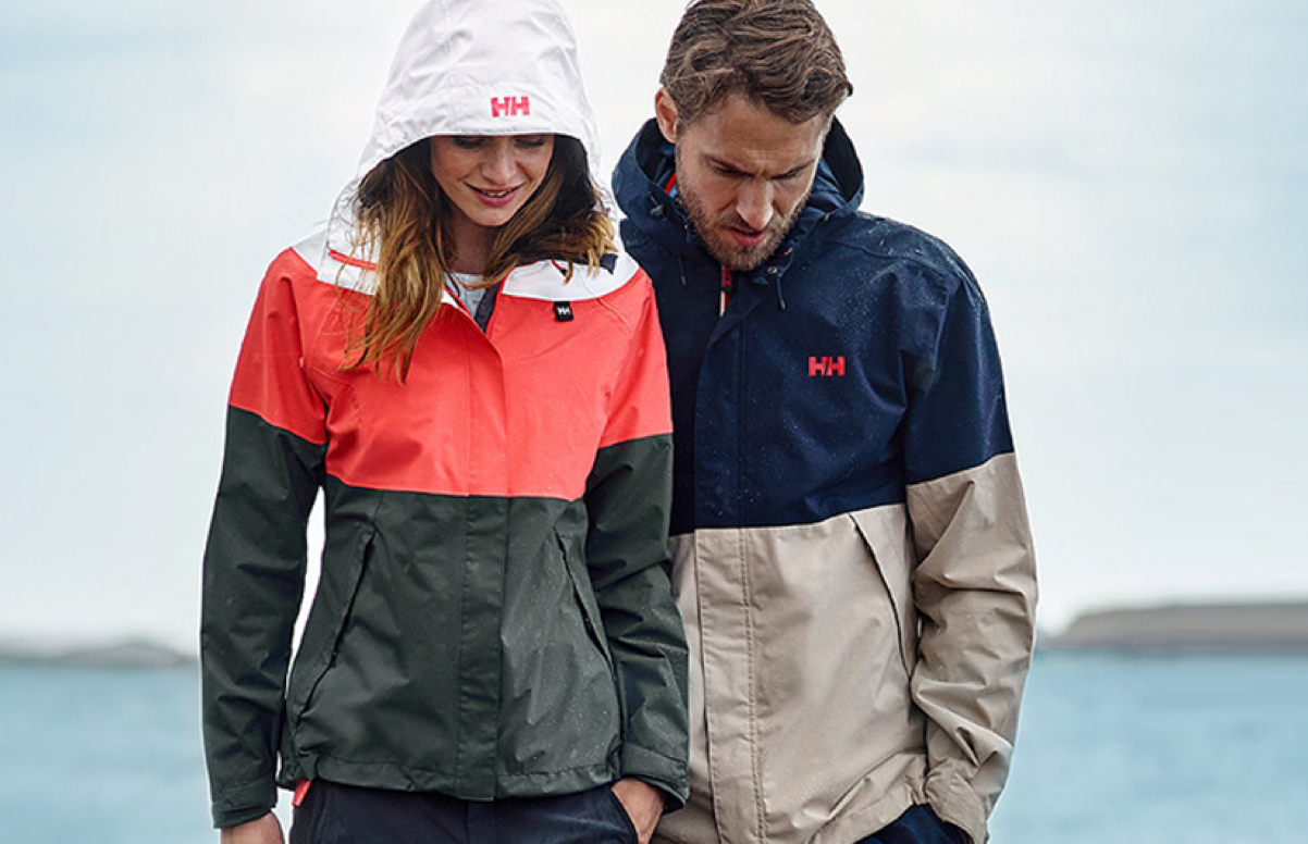 Couple in waterproof coats taking walk on a coast