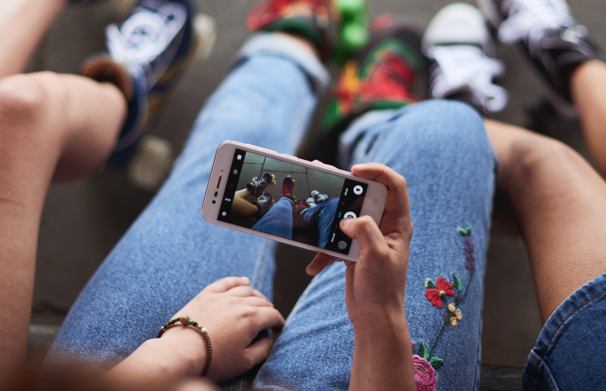 Young kids looking at an iphone taking a photo